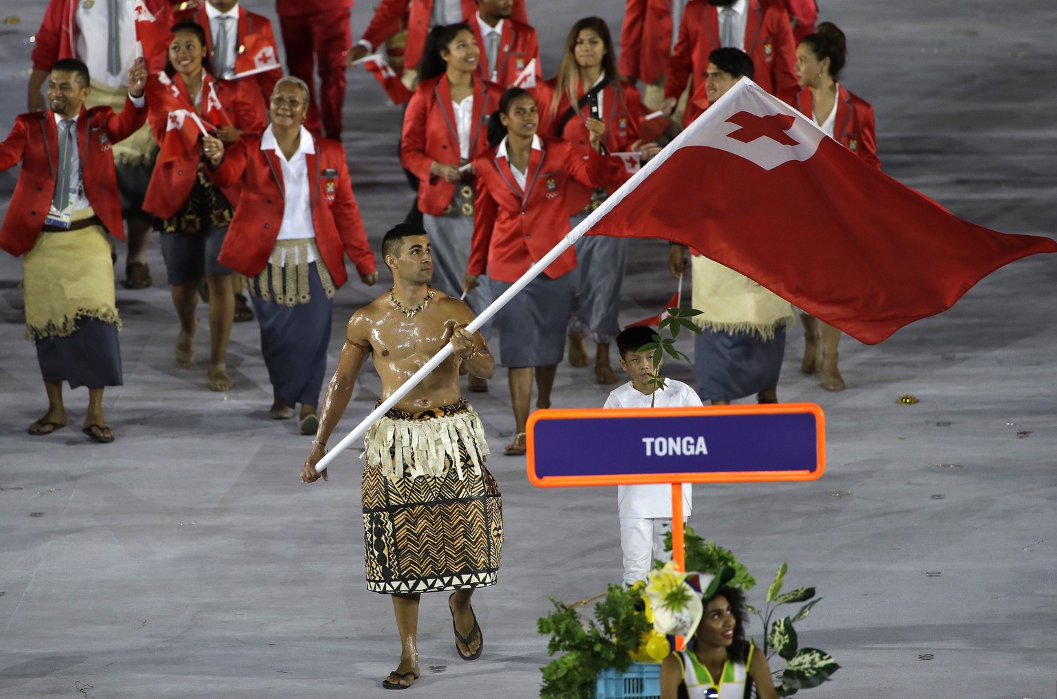 CORRECTS SPELLING OF NAME TO TAUFATOFUA INSTEAD OF AUFATOFUA - Pita Nikolas Taufatofua carries the flag of Tonga during the opening ceremony for the 2016 Summer Olympics in Rio de Janeiro, Brazil, Fri ...