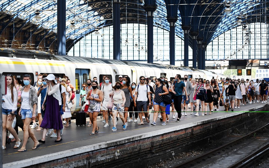 epa08508261 Passengers disembark a packed train as people make their way to Brighton beach, in Brighton, Britain, 25 June 2020. Temperatures of 33 degrees Celsius have brought people to the beaches an ...