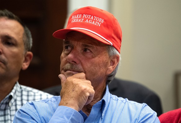 epa07595719 A farmer wears a President Donald Trump themed hat listens as he delivers remarks on supporting American farmers, in the Roosevelt Room at the White House in Washington, DC, USA, 23 May 20 ...