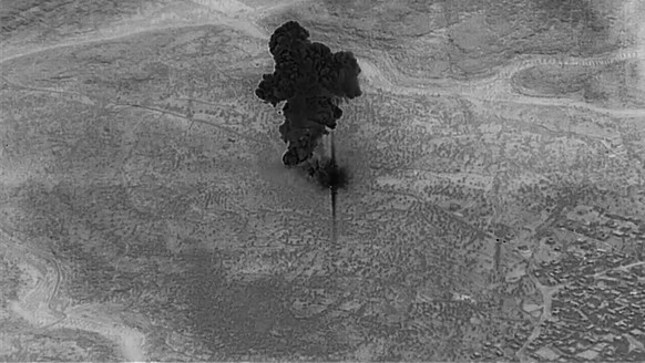 epa07961151 A screengrab from a handout military drone video made available by the US Defense Video and Imagery Distribution System (DVIDS) shows a smoke cloud from the compound of ISIS Leader Abu Bak ...