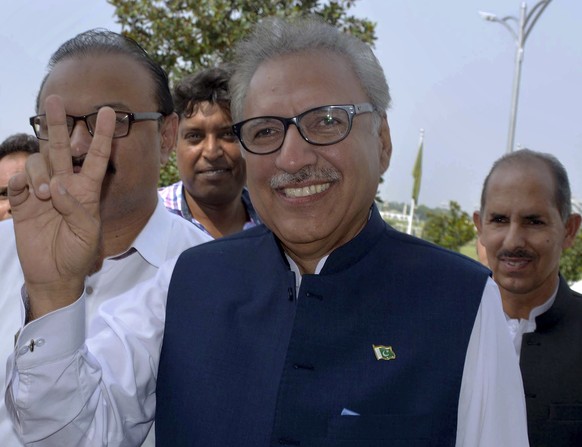 Arif Alvi, presidential candidate from the ruling Pakistan Tehreek-e-Insaf Party, makes a victory sign upon arrival at parliament in Islamabad, Pakistan, Tuesday, Sept. 4, 2018. Polling started at Pak ...
