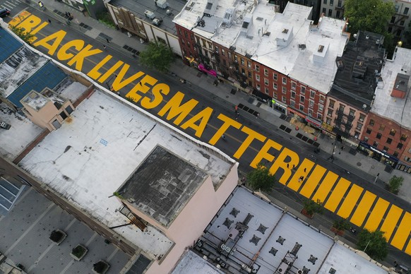 FILE - In this June 15, 2020, file photo, a sign reading &quot;Black Lives Matter,&quot; is painted in orange on Fulton Street in the Brooklyn borough of New York. On Thursday, June 25, 2020, Presiden ...