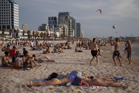 People enjoy the beach front in Tel Aviv, Israel, Saturday, May 16, 2020. Israeli authorities have recently begun loosening the restrictions of the coronavirus lockdown, the easing brought people out  ...
