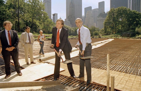 New York City Parks Commissioner Henry Stern, right, and real estate mogul Donald Trump, lift shovels of cement to mark the start of concrete pouring in Central Park&#039;s Wollman Rink, Sept. 10, 198 ...
