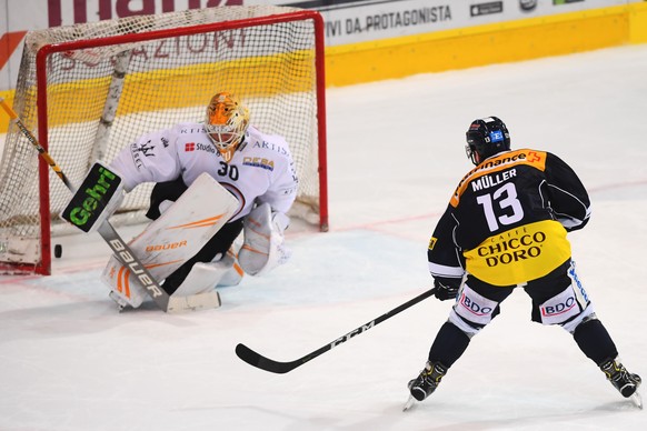 Ambri&#039;s player Marco Mueller, right, scores a penalty shot against Lugano&#039;s goalkeeper Elvis Merzlikins, left, during the regular season game of the National League Swiss Championship 2018/1 ...
