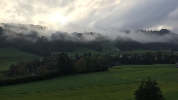 Blick auf nebelverhangene Hügel im Toggenburg.