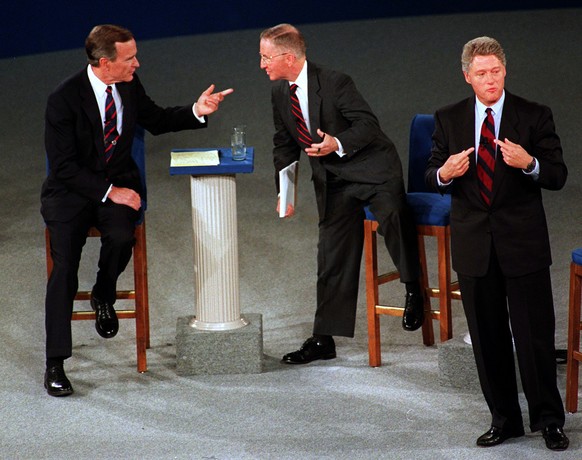 In this Oct. 15, 1992 photo, President Bush, left, talks with independent candidate Ross Perot as Democratic candidate Bill Clinton stands aside at the end of their second presidential debate in Richm ...