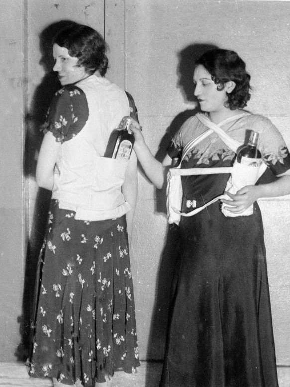 Estelle Zemon, left, and an unidentified woman model ways to conceal bottles of rum to get past customs officials during the U.S. alcohol prohibition, March 18, 1931. (AP Photo)