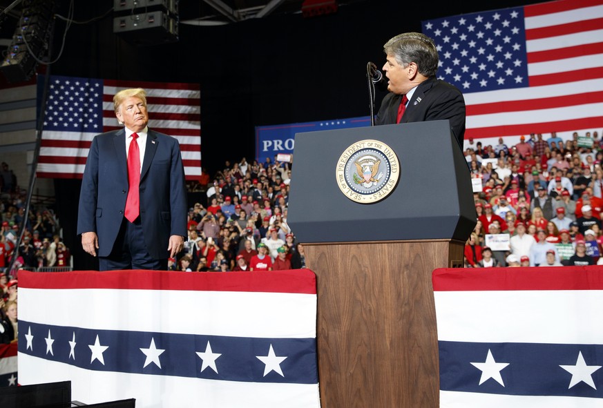 President Donald Trump listens Fox News&#039; Sean Hannity speak during a rally at Show Me Center, Monday, Nov. 5, 2018, in Cape Girardeau, Mo.. (AP Photo/Carolyn Kaster)