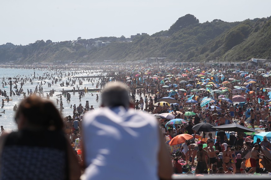 People are seen on the beach on the hottest day of the year, after an easing of social restrictions due to coronavirus, in Bournemouth, England, Wednesday, June 24, 2020. Temperatures reached 32.6C (9 ...