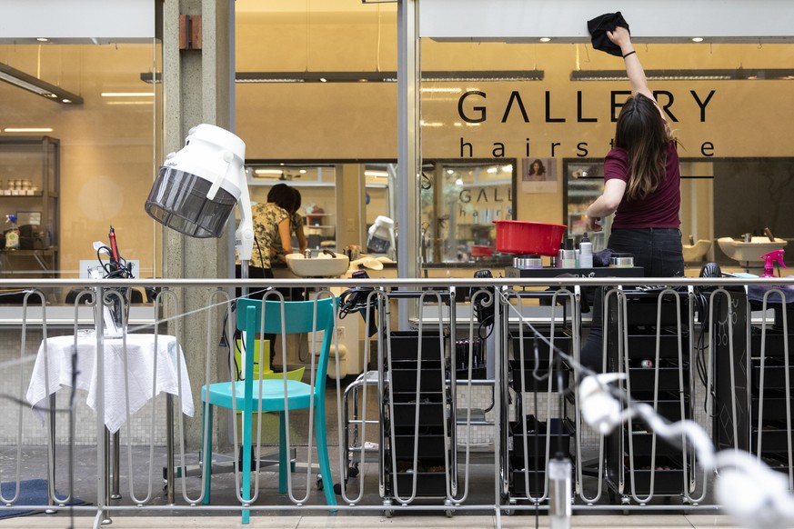 Eine Angestellte des Coiffeursalons Gallery Hairstyle reinigt die Fenster des Coiffeursalons, am Dienstag, 21. April 2020 in Bern. Coiffeure duerfen ihre Geschaefte ab dem 27.4.2020 wieder oeffnen. (K ...