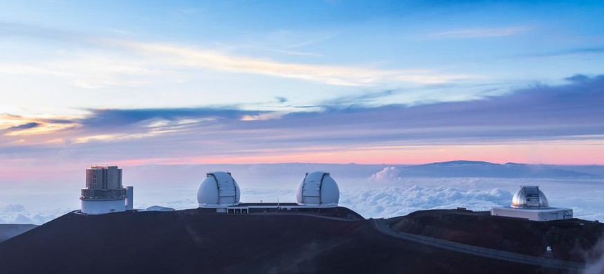 Über der Hauptwolkenschicht schweben bei Sonnenuntergang zwischen den Beobachtungsstellen auf dem Vulkan Mauna Kea, Hawaii. Dargestellt sind Subaru Telescope, Keck I und II und NASA Infrared Telescope ...