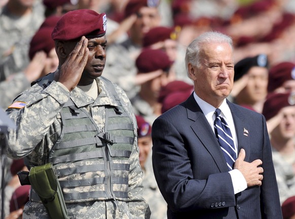 epa08869605 (FILE) - Then US Vice President Joe Biden (R) next to Lieuteneant General Lloyd J. Austin III during the US national anthem during a special ceremony at Fort Bragg outside Fayetteville, No ...