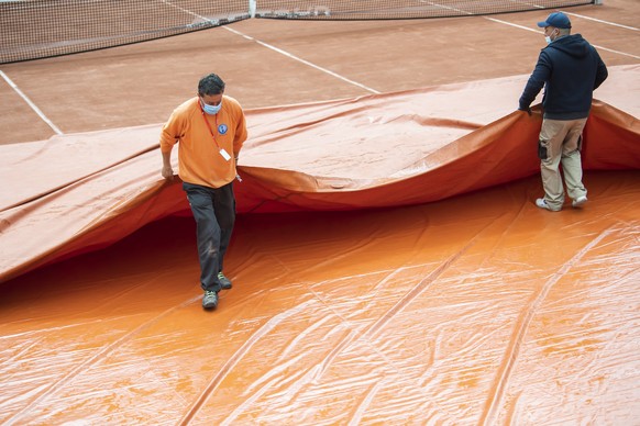Staff remove the rain cover from the cour of round match between Henri Laaksonen from Switzerland and Alejandro Tabilo from Chile, during the qualifying match, at the ATP 250 Tennis Geneva Open tourna ...
