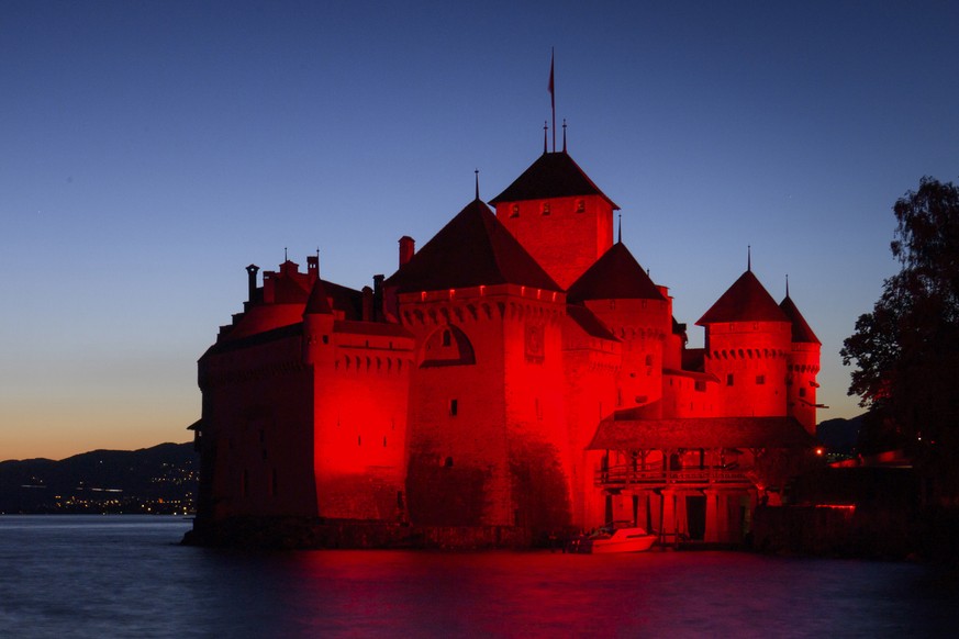 epaselect epa08502852 The Chillon Castle is lit up in red on the shore of Lake Geneva during the&#039;Night of Light campaign, in Veytaux near Montreux, Switzerland, 22 June 2020. Monday evening numer ...