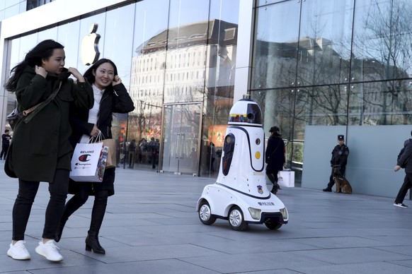 A police robot is stationed near an Apple store in Beijing, China, Wednesday, March 6, 2019. China&#039;s emergence as a competitor in key technologies such as smartphones and telecoms equipment has r ...