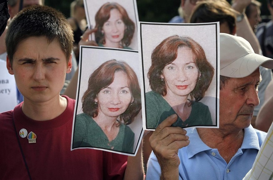 epa01796354 People hold portraits of journalist and human rights activist Natalia Estemirova, during a rally for the murder victim in Moscow, Russia on 16 July 2009. Natalia Estemirova was abducted in ...