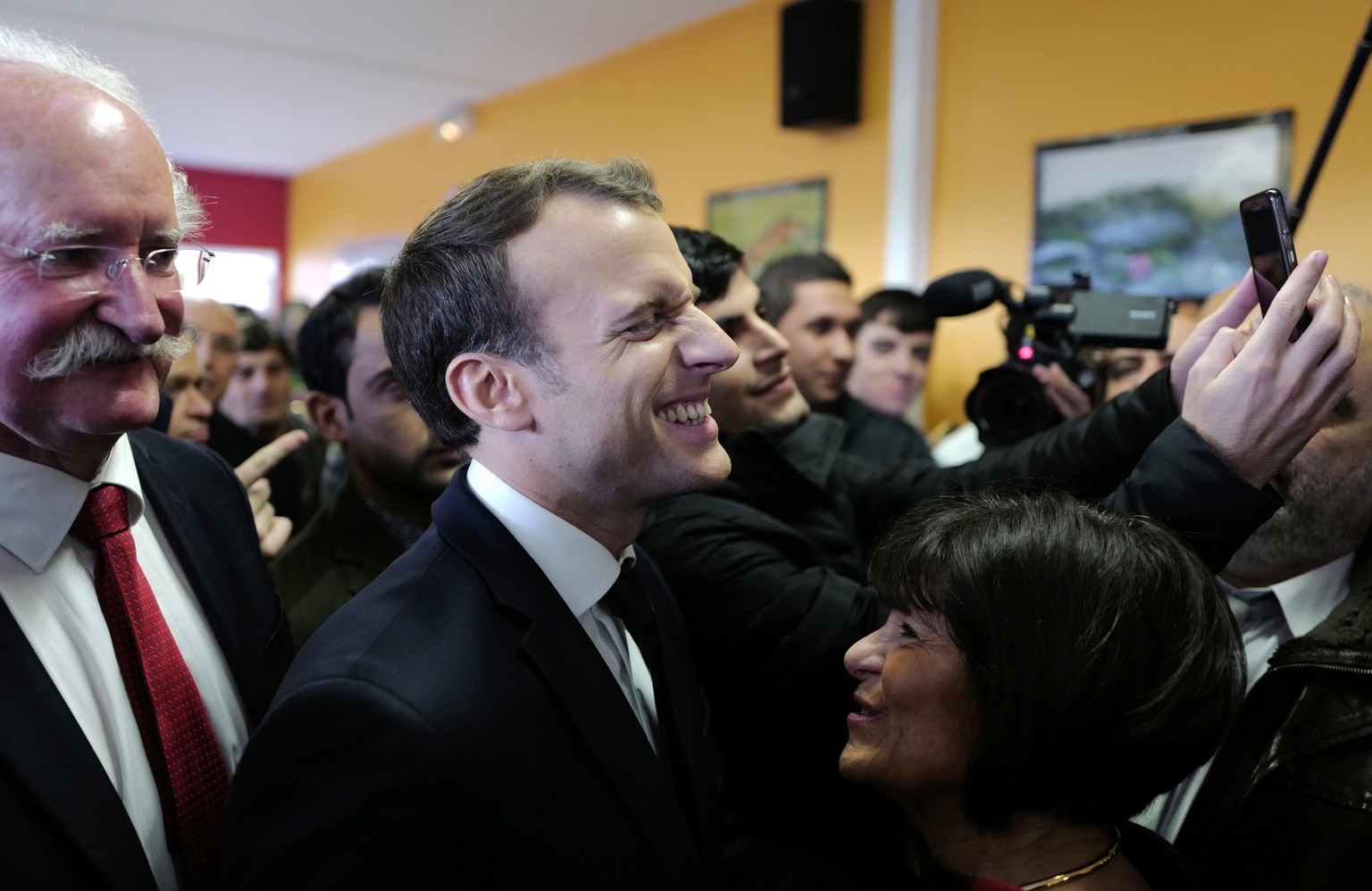 French President Emmanuel Macron laughs during his visit to a migrant center in Croisilles, northern France, Tuesday, Jan.16, 2018. Macron is making a foray into the symbolic heart of France&#039;s mi ...