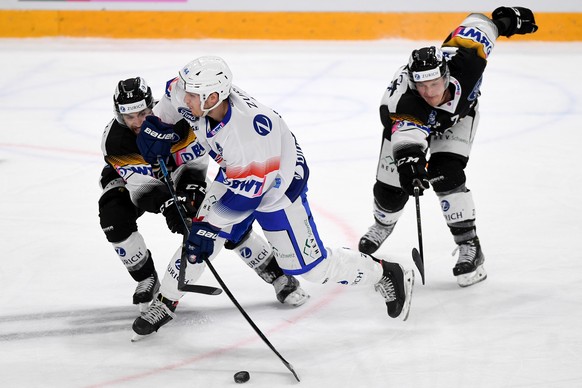 Lugano&#039;s player Mark Arcobello, ZSC&#039;s player Pius Suter, and Lugano&#039;s player Daniel Carr, from left, fight for the puck, during the 1/8 final game of Swiss Cup 2020/21 between HC Lugano ...