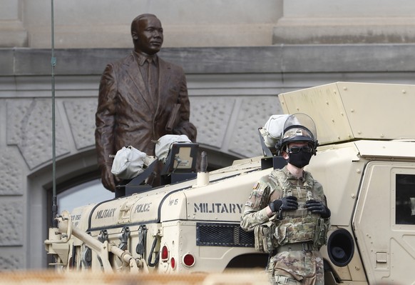 epa08944482 Georgia National Guard members stand near a statue of Martin Luther King Jr. as they and Georgia State Troopers guard the Georgia Capitol Building ahead of planned pro-Trump protests in At ...