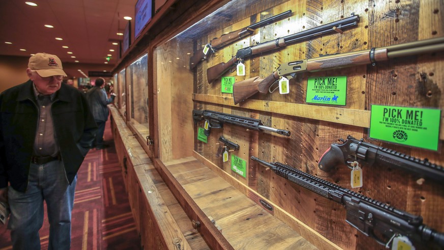 epa07528720 A man looks at firearms on display at the 2019 National Rifle Association (NRA) Annual Convention at the Indianapolis Convention Center in Indianapolis, Indiana, USA, 25 April 2019. Firear ...