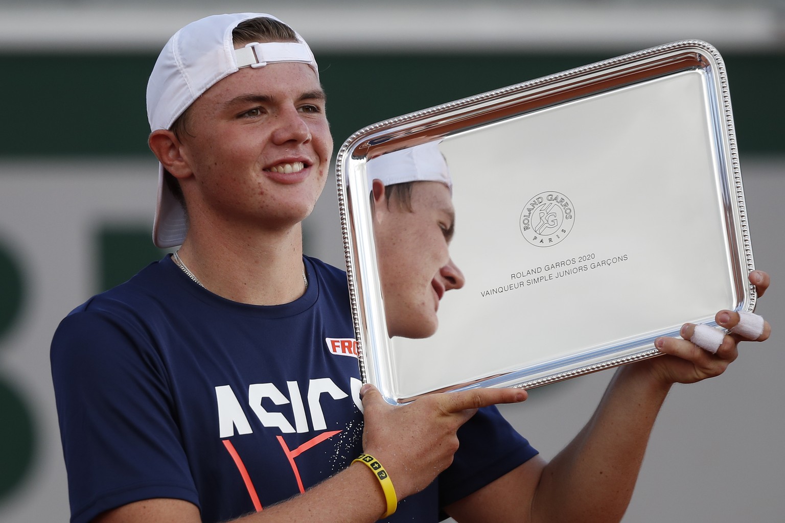 Switzerland&#039;s Dominic Stephan Stricker holds the trophy after winning the junior men&#039;s final match of the French Open tennis tournament against Switzerland&#039;s Leandro Riedi at the Roland ...