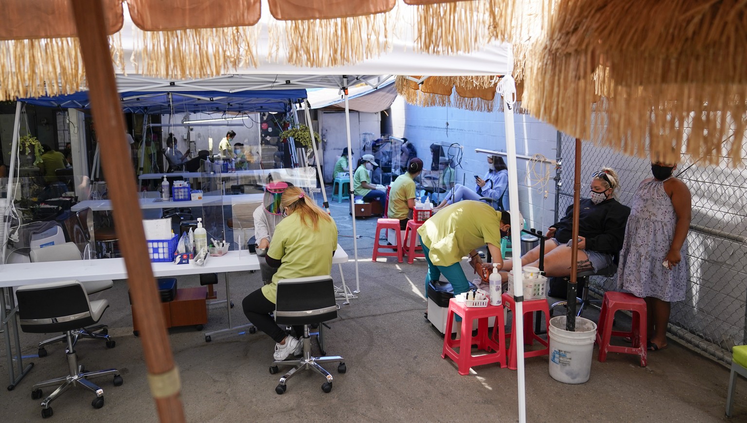 Customers get their nails done outside Pampered Hands nail salon on Wednesday, July 22, 2020, in Los Angeles. The salon is allowed to operate outside. California&#039;s confirmed coronavirus cases hav ...