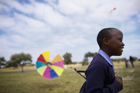 epaselect epa04468186 A South African child from the Cape Mental Health Special Care centre flies a kite as part of a special preview showcase for the Cape Town International Kite Festival in Khayelit ...