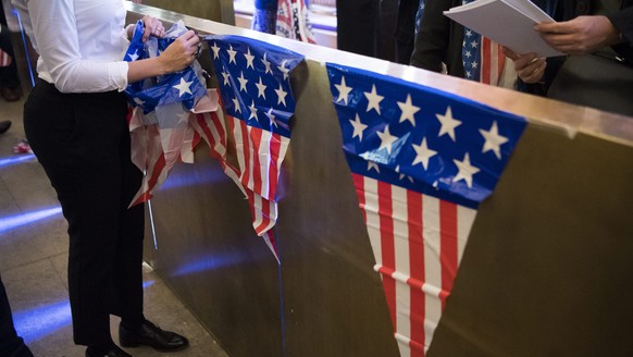 epa05623700 A woman removes an American flag during an election party organized by the US embassy at the Kornhaus Cafe in Bern, Switzerland, 09 November 2016. Americans vote the 45th President of the  ...