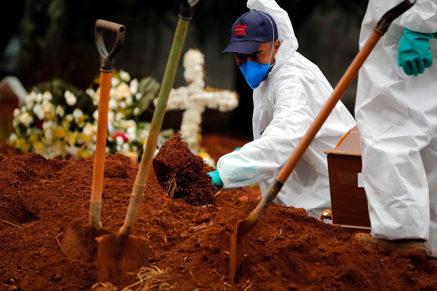 Ein Arbeiter hebt ein Grab in São Paulo aus.