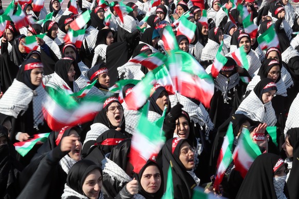 epa08210636 Female students wave Iranian national flags during a ceremony marking the 41st anniversary of the 1979 Islamic Revolution, at the Azadi (Freedom) square in Tehran, Iran, 11 February 2020.  ...
