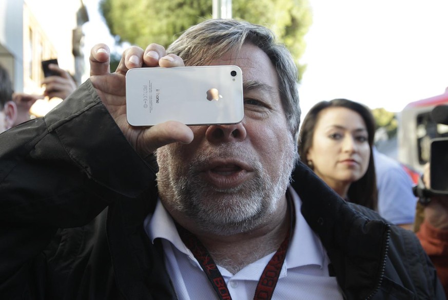 Apple co-founder Steve Wozniak holds up his new Apple iPhone 4S at the Apple store in Los Gatos, Calif., Friday, Oct. 14, 2011. Wozniak waited 20 hours in line to be the first Apple customer at the Lo ...