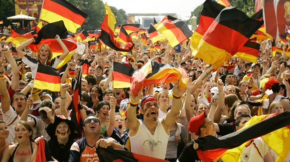German soccer fans cheer as Germany scores the first goal during the World Cup soccer match Germany against Ecuador as they watch the game on a giant TV screen at the public viewing area in Berlin, Tu ...