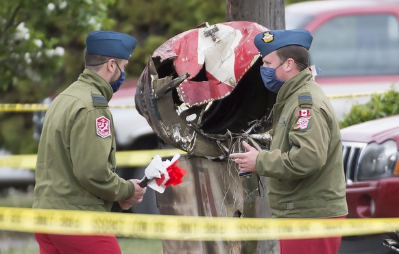 Canadian Forces Snowbird captains Erik Temple, right, and Joel Wilson check out the crash scene of a Canadian Forces Snowbird plane in Kamloops, Canada, Sunday, May 17, 2020. A Canadian aerobatic jet  ...