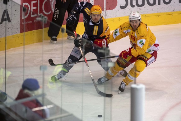 Ambri&#039;s player Jannick Fischer and Bienne&#039;s player Marc-Antoine Pouliot, from left, during the second leg of the playoff quarterfinals of the ice hockey National League Swiss Championship be ...