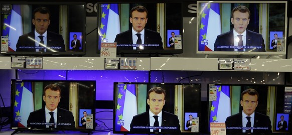TV screens show French President Emmanuel Macron during a televised address to the nation, at an electrical appliance store in Marseille, southern France, Monday, Dec. 10, 2018. President Emmanuel Mac ...