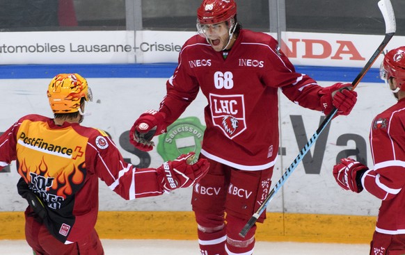 L&#039;attaquant lausannois Sven Ryser, centre, celebre le premier but avec le Top Scorer lausannois Yannick Herren, gauche, lors du match du championnat suisse de hockey sur glace de National League  ...