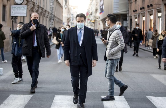 epaselect epa08933209 Italian Prime Minister Giuseppe Conte (C) walks down Via del Corso, in Rome, Italy, 12 January 2021. The anti-establishment 5-Star Movement (M5S) and the center-left Democratic P ...