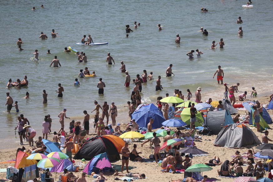 Crowds gather at the water&#039;s edge as hot weather draws crowds to the beach in Bournemouth, England, Thursday June 25, 2020. Coronavirus lockdown restrictions are being relaxed but people should s ...