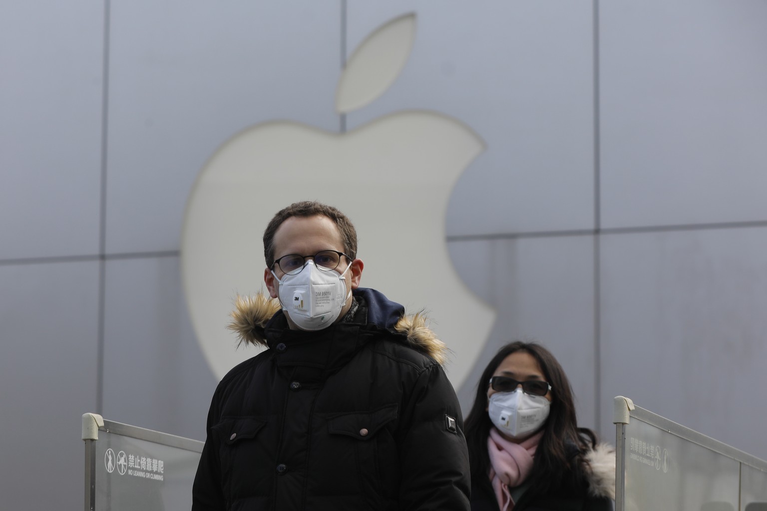 epaselect epa08186957 People wear masks as they walk past a closed Apple store at Sanlitun in Beijing, China, 02 February 2020. Apple announced the closure of its stores, corporate offices and contact ...