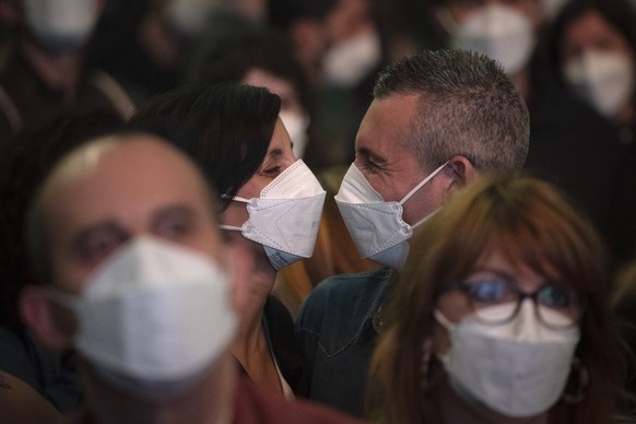 People using face masks attend a music concert in Barcelona, Spain, Saturday, March 27, 2021. Five thousand music lovers were set to attend a rock concert in Barcelona on Saturday after passing a same ...