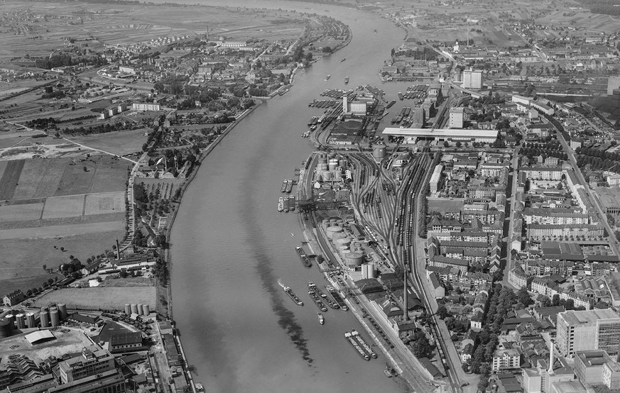Die Basler Rheinhäfen im Jahr 1954. Unten rechts: Teile der Firma CIBA. Im Hafengelände sticht die ganz neu gebaute Stückgut-Umschlagsanlage der Schweizerischen Reederei AG ins Auge. Am gegenüber lieg ...