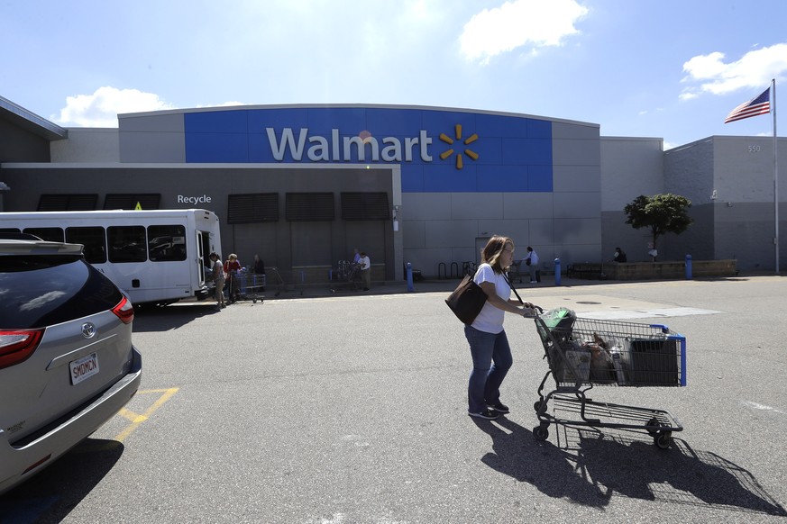 A customer pushes a shopping cart Tuesday, Sept. 3, 2019, outside a Walmart store, in Walpole, Mass. Walmart is going back to its folksy hunting heritage and getting rid of anything that&#039;s not re ...