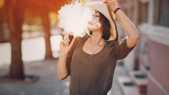 Junge Frau mit Vaporizer / E-Zigarette.