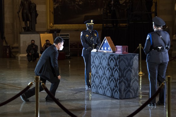 epa08983227 A man pays respects at the remains of late Capitol Police officer Brian Sicknick as he lies in honor in the Rotunda of the US Capitol building in Washington DC, US, 02 February 2021. Offic ...