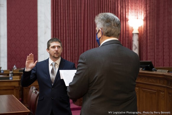 West Virginia House of Delegates member Derrick Evans, left, is given the oath of office Dec. 14, 2020, in the House chamber at the state Capitol in Charleston, W.Va. Evans, a West Virginia state lawm ...