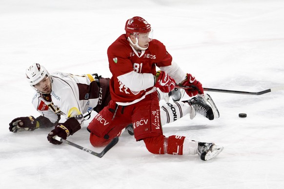 Geneve-Servette&#039;s defender Arnaud Jacquemet, left, vies for the puck with Lausanne&#039;s forward Ronalds Kenins, of Latvia, right, during a National League regular season game of the Swiss Champ ...