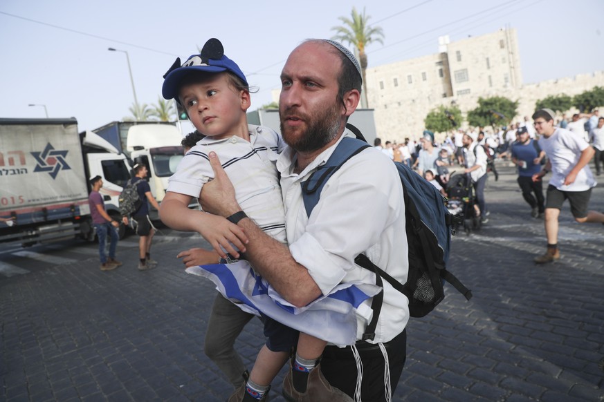 Israelis run to shelters as air attack sirens goes off during a Jerusalem Day march, in Jerusalem, Monday, May 10, 2021. Israeli police have changed the route of a contentious march by Jewish ultranat ...