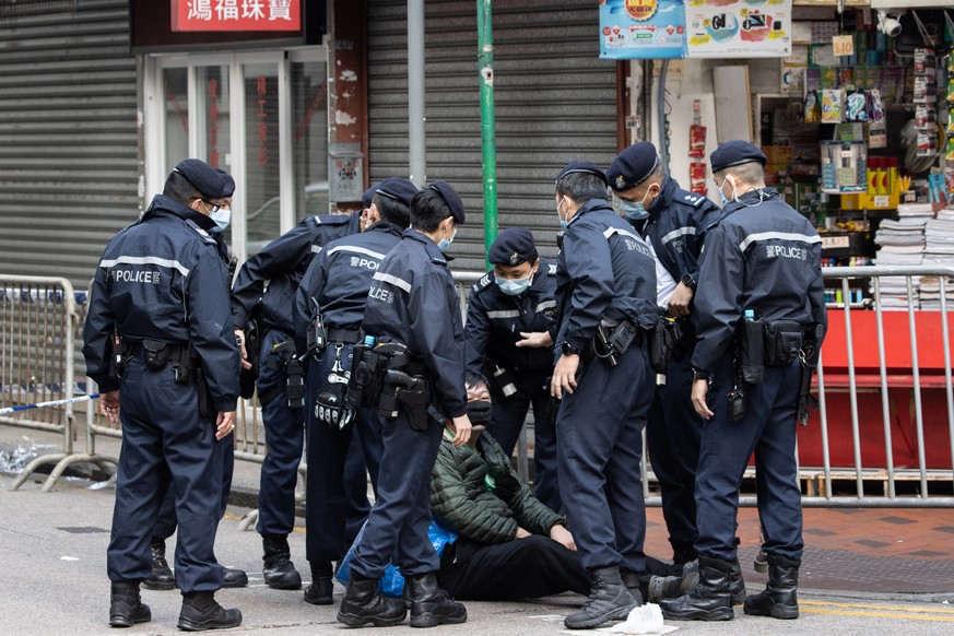 epa08959112 Police detain a man after he hit a policeman who refused to let him in an area under lockdown in Jordan, Hong Kong, China, 23 January 2021. The Hong Kong government placed around 10,000 re ...