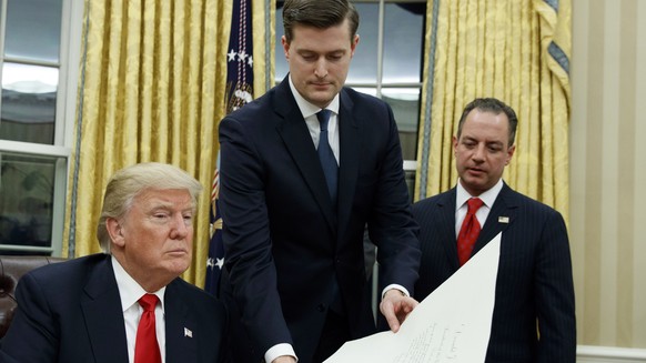 FILE - In this Jan. 20, 2017 file photo, White House Staff Secretary Rob Porter, center, hands President Donald Trump a confirmation order for James Mattis as defense secretary, in the Oval Office of  ...